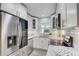 Modern kitchen with stainless steel appliances, white cabinetry, and a view of lush greenery at 730 40Th St, Sarasota, FL 34234