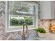 Kitchen sink with marble backsplash, modern faucet, and natural light from the garden view window at 730 40Th St, Sarasota, FL 34234