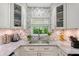 Bright kitchen with a stainless steel sink, white cabinets, and elegant marble countertops at 730 40Th St, Sarasota, FL 34234