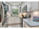 Updated kitchen with stainless appliances, herringbone backsplash, and sleek white cabinetry at 730 40Th St, Sarasota, FL 34234
