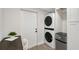 A well-lit laundry area featuring a stacked washer and dryer and a desk at 730 40Th St, Sarasota, FL 34234