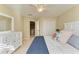 Bright bedroom with a queen-size bed, dresser, and access to a hallway at 14019 18Th E Pl, Bradenton, FL 34212