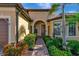 Inviting front entrance with lush landscaping, a brick walkway, and an arched entryway at 19864 Petrino St, Venice, FL 34293