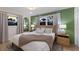Serene bedroom with green accent wall, a cozy bed, and ample natural light at 213 83Rd St # East, Holmes Beach, FL 34217
