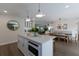 Open kitchen with breakfast bar, white cabinets, and a view of the dining area at 213 83Rd St # East, Holmes Beach, FL 34217