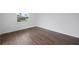 Simple bedroom with dark brown wood-look flooring and one window at 3919 116Th Street W Ct, Bradenton, FL 34210