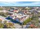 A sunny aerial view of condo buildings featuring red tile roofs and neatly landscaped common areas in a commercial area at 461 Nokomis S Ave, Venice, FL 34285