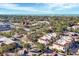 High aerial view of the town featuring red-roofed townhomes, trees, and ocean in the distance at 461 Nokomis S Ave, Venice, FL 34285