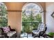 Relax on this charming balcony with comfortable seating and beautiful treetop views at 461 Nokomis S Ave, Venice, FL 34285