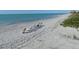 Picturesque beach scene with lounge chairs on the sand, gently lapping waves, and clear skies at 461 Nokomis S Ave, Venice, FL 34285
