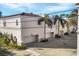 Exterior view of townhomes with garages, showcasing the landscaping and red tile roof at 461 Nokomis S Ave, Venice, FL 34285