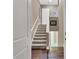 Interior staircase with hardwood floors, carpeted stairs, neutral walls, and white trim and doors at 461 Nokomis S Ave, Venice, FL 34285