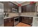 Kitchen with stainless steel appliances, granite countertops, and dark wood cabinets at 461 Nokomis S Ave, Venice, FL 34285