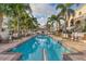 Inviting swimming pool lined with palm trees, lounge chairs and tables, surrounded by well-maintained landscaping at 461 Nokomis S Ave, Venice, FL 34285