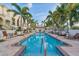 Inviting swimming pool lined with palm trees, lounge chairs and tables, surrounded by well-maintained landscaping at 461 Nokomis S Ave, Venice, FL 34285