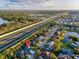 High-angle view of the property showcasing its location near a highway, water, and the surrounding community at 4877 Post Pointe Dr, Sarasota, FL 34233