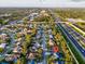 Expansive aerial view shows the neighborhood, a nearby highway, and lush greenery surrounding the home at 4877 Post Pointe Dr, Sarasota, FL 34233