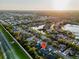Beautiful aerial view of the home nestled in a neighborhood with mature trees and a nearby pond at sunset at 4877 Post Pointe Dr, Sarasota, FL 34233