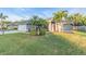 Beautiful single-story home featuring a well-manicured lawn and tropical landscaping at 4877 Post Pointe Dr, Sarasota, FL 34233