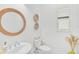 Powder room featuring a stylish round mirror and neutral color scheme at 5035 Kiva Cir, Bradenton, FL 34211