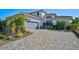 Charming two-story home with tropical landscaping, a two-car garage, and a beautiful brick driveway at 5035 Kiva Cir, Bradenton, FL 34211