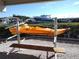 Orange kayak on rack with bench, near waterfront with boats at 515 Leffingwell Ave # 109, Ellenton, FL 34222