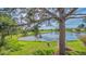 Serene pond view with lush landscaping and mature trees at 5242 Wedgewood Ln # 62, Sarasota, FL 34235