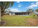 Spacious backyard with grassy area and screened patio at 530 Saint Andrews Dr, Sarasota, FL 34243