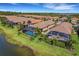 Aerial view of homes with pools and screened enclosures, located by a lake at 5341 Popoli Way, Sarasota, FL 34238