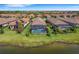 Aerial view of houses with pools and screened enclosures near a lake at 5341 Popoli Way, Sarasota, FL 34238