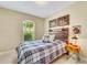 Serene bedroom with rustic wooden headboard and plaid bedding at 5341 Popoli Way, Sarasota, FL 34238