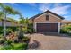 Single-story home with brown garage door and landscaping at 5341 Popoli Way, Sarasota, FL 34238
