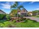 House exterior featuring a landscaped yard, driveway, and two-car garage at 5341 Popoli Way, Sarasota, FL 34238