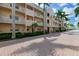 Inviting condo building with palm trees and brick driveway at 5968 Midnight Pass Rd # 164, Sarasota, FL 34242