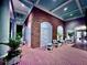 Brick clubhouse patio with seating area and lush plants at night at 6501 Stone River Rd # 203, Bradenton, FL 34203