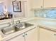 Kitchen with double sink and updated backsplash at 6501 Stone River Rd # 203, Bradenton, FL 34203