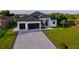 Modern home with two-car garage, paver driveway, and grassy lawn at 8 Idle Ct, Placida, FL 33946