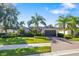 Beautiful home featuring a well-manicured lawn, palm trees, and a brick driveway with blue skies at 942 Preservation St, Bradenton, FL 34208