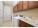 Laundry room featuring overhead cabinetry, sink, and a side-by-side washer and dryer at 942 Preservation St, Bradenton, FL 34208