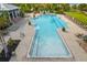 Large community pool with lounge chairs, tables, and umbrellas, perfect for relaxing outdoors at 942 Preservation St, Bradenton, FL 34208