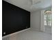 Minimalist bedroom featuring a dark accent wall, neutral carpet, and natural light at 963 River Wind Cir, Bradenton, FL 34212