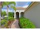 Inviting front entry with brick walkway, lush landscaping, and a charming, dark-blue door at 963 River Wind Cir, Bradenton, FL 34212