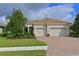 Charming two-car garage home featuring a well manicured lawn, lovely landscaping and a paver driveway at 963 River Wind Cir, Bradenton, FL 34212