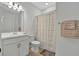 Clean bathroom with white vanity, shower, and striped shower curtain at 10358 Abaco Falls Dr, Englewood, FL 34223