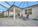Relaxing covered patio with pavers and seating, overlooking the backyard at 10358 Abaco Falls Dr, Englewood, FL 34223