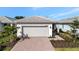 Front view of the house showing a two-car garage and landscaping at 10358 Abaco Falls Dr, Englewood, FL 34223
