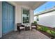 Front porch with blue door and wicker seating at 10358 Abaco Falls Dr, Englewood, FL 34223