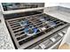 Close-up view of a gas cooktop with blue flames at 10358 Abaco Falls Dr, Englewood, FL 34223