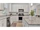 Modern kitchen with white cabinets, granite counters & stainless steel appliances at 10358 Abaco Falls Dr, Englewood, FL 34223