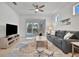 Living room with gray sofa and access to patio and pool at 10358 Abaco Falls Dr, Englewood, FL 34223